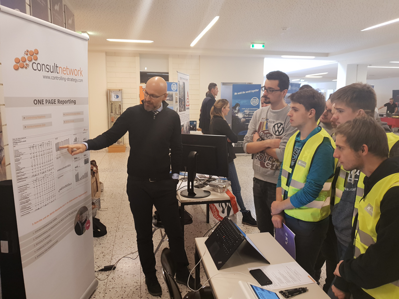 Mario Rosenfelder erklärt den interessierten HTL Schülern mithilfe eines Roll Ups was die Tätigkeiten von consultnetwork sind.